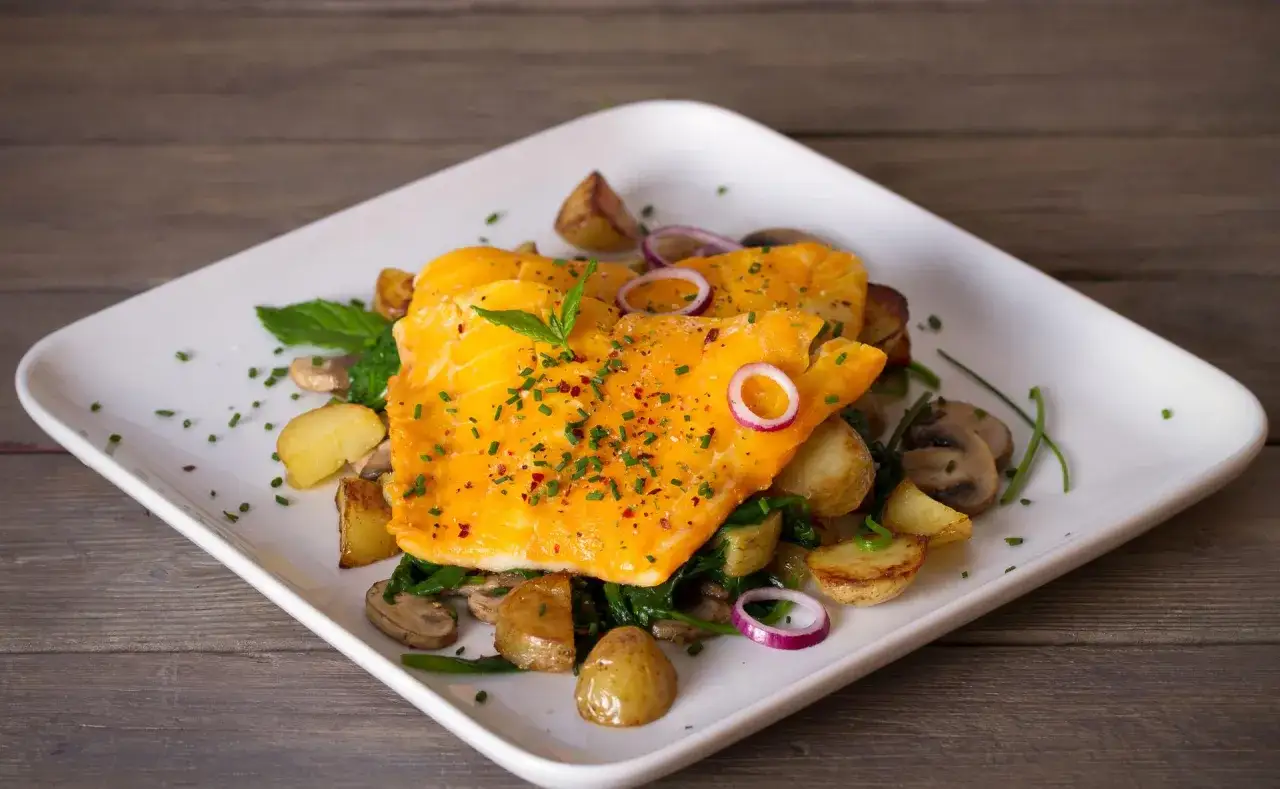 D&eacute;licieux haddock cuit, servi avec des pommes de terre r&ocirc;ties, des champignons, des &eacute;pinards et des oignons rouges. Une assiette color&eacute;e et app&eacute;tissante.