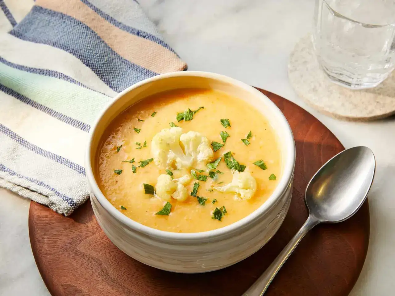 Un réconfortant potage Dubarry, crémeux et garni de fleurettes de chou-fleur et de persil frais.