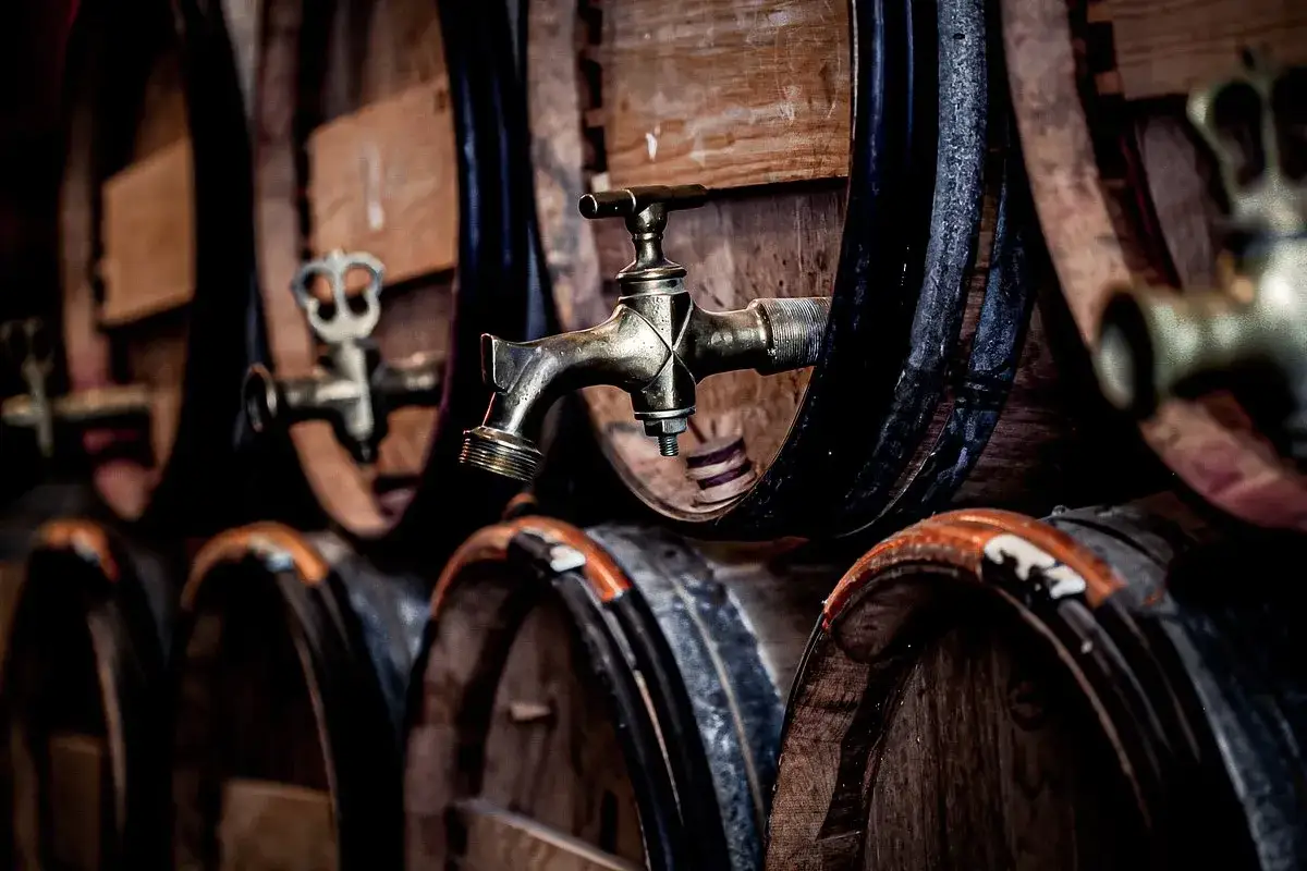 Robots de cuivre sur des tonneaux de vin dans une cave du Médoc.