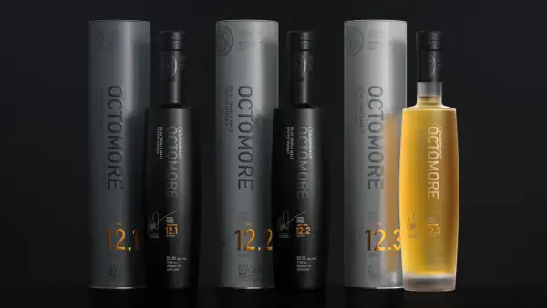 Trois bouteilles d'Octomore, whisky tourbé d'Islay, avec leurs tubes. L'une est dorée, les deux autres noires. Les étiquettes affichent des niveaux de PPM élevés, comme 130.8 PPM.