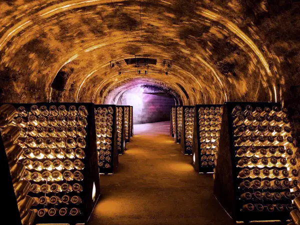 Cave de champagne à Reims, une idée de que faire à Reims. Des milliers de bouteilles dorment dans ce tunnel voûté illuminé.