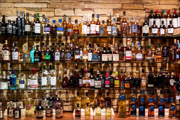 Étagères remplies de bouteilles de whisky et de champagne, un festin pour les amateurs de spiritueux.