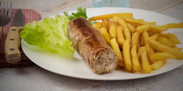 Une belle andouillette grillée avec des frites croustillantes et une feuille de laitue fraîche. Un plat simple et savoureux.