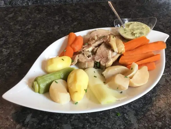 Plat de tête de veau, carottes, pommes de terre et poireaux, servi avec une sauce tartare. Une recette traditionnelle pour un repas réconfortant.
