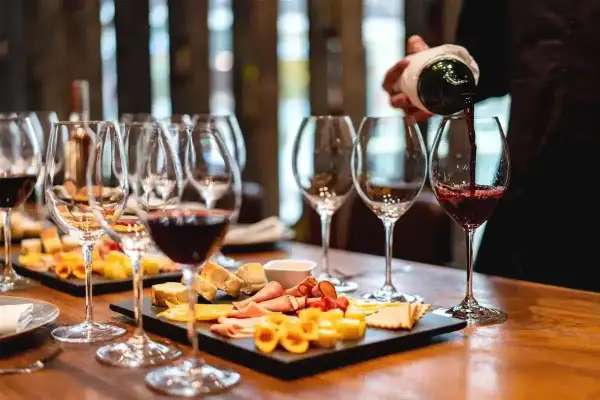 Une dégustation de vin à Paris, avec des verres remplis de vin rouge et des plateaux de fromages et charcuteries.