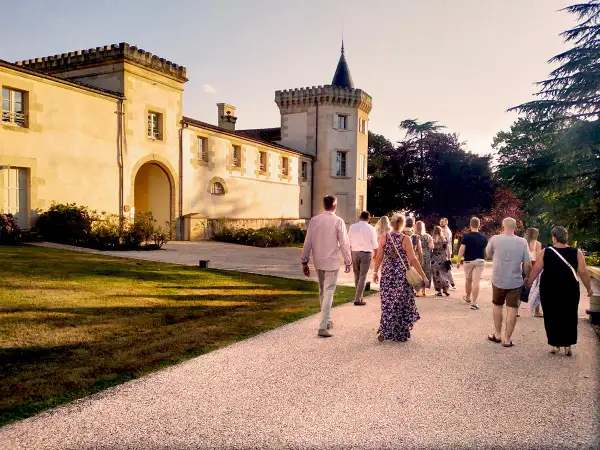 Un groupe de personnes se promène sur le chemin menant au **château Toulouse Lautrec** au coucher du soleil.