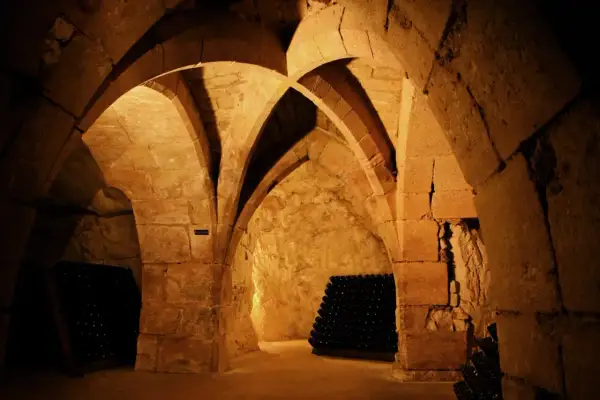 Cave voûtée de la maison Taittinger à Reims, où des milliers de bouteilles de champagne vieillissent patiemment.