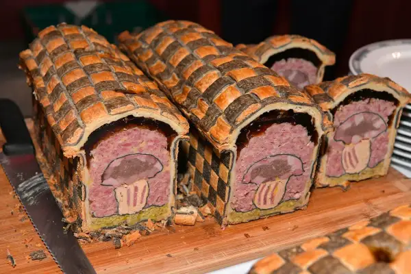 Pâté en croûte d'origine, décoré d'un champignon stylisé. Une œuvre culinaire qui raconte l'histoire de ce plat traditionnel.