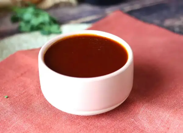 Un bol de sauce barbecue maison, parfaite pour accompagner vos grillades. Une recette simple pour un goût authentique.