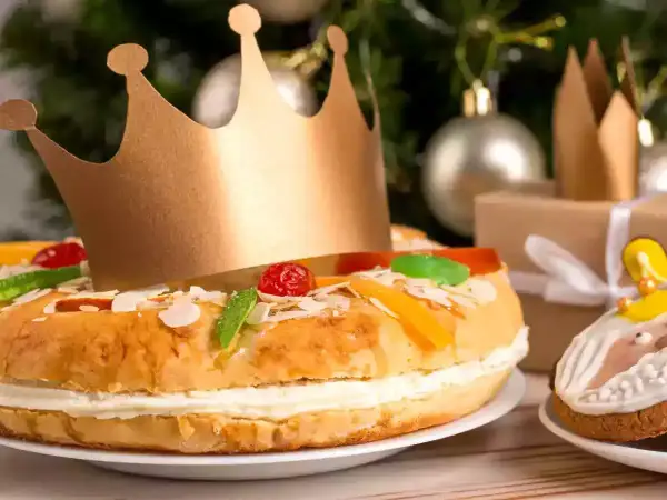 Un gâteau pour accompagner le champagne, décoré de fruits confits et d'une couronne dorée, prêt pour une fête royale.