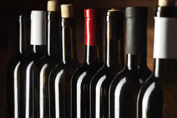 Bouteilles de vin alignées, certaines avec bouchons en liège, d'autres avec capsules. Un aperçu des trésors d'un domaine viticole Roussillon.