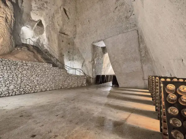 Visite cave Ruinart : avis sur ces crayères historiques où le champagne vieillit. Bouteilles en pupitres, escaliers de pierre.
